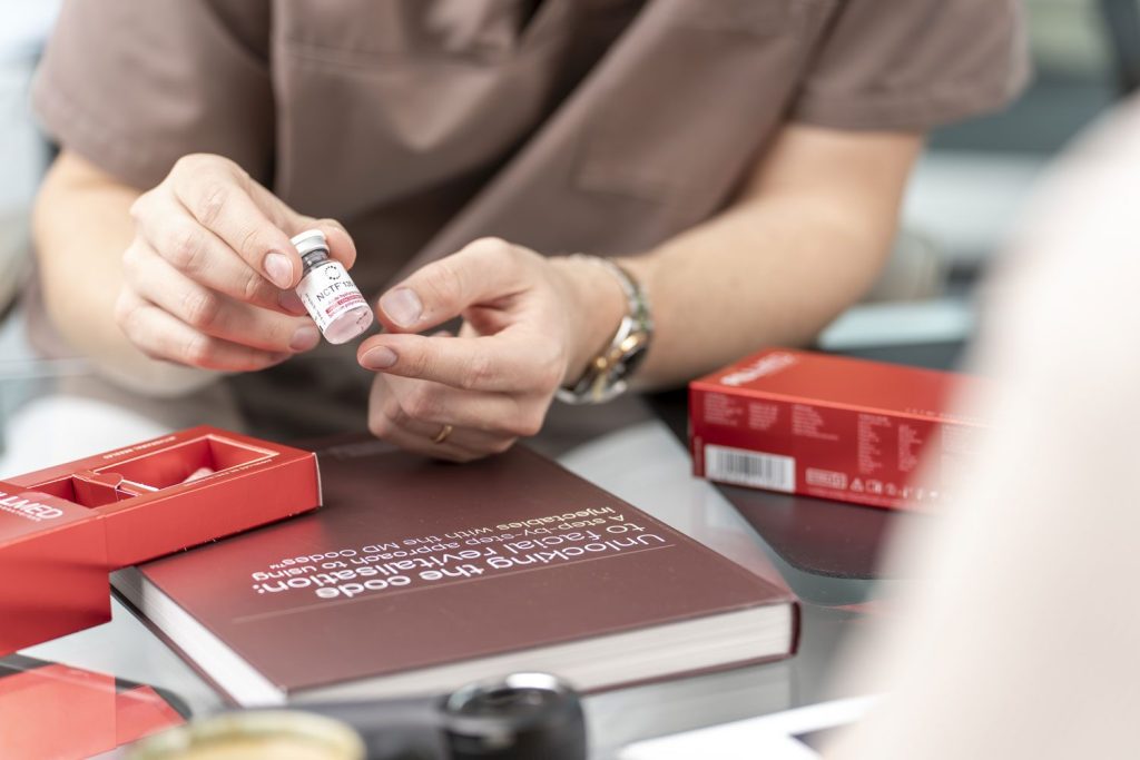 Hände prüfen ein kleines Produkt am Arbeitstisch – Detailaufnahme für Corporate-Fotografie