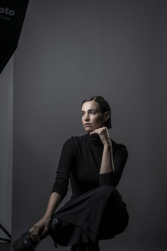 Studioportrait einer Frau in Schwarz, sitzend vor dunklem Hintergrund – Fotostudio Karlsruhe-Durlach